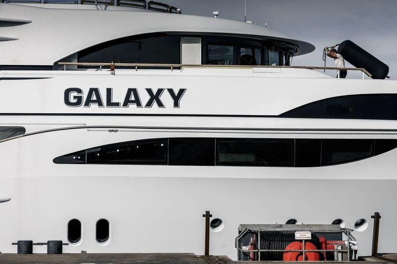 a white boat with a black and white sign on the front aboard GALAXY Yacht for Sale