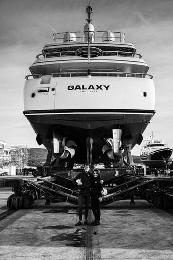 a couple of men standing next to a large ship aboard GALAXY Yacht for Sale