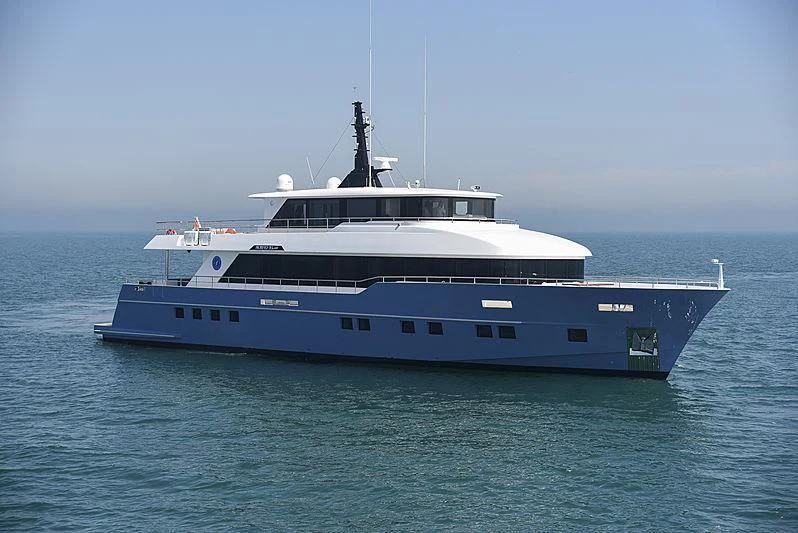 a large blue and white boat in the water aboard DIGNITY Yacht for Sale