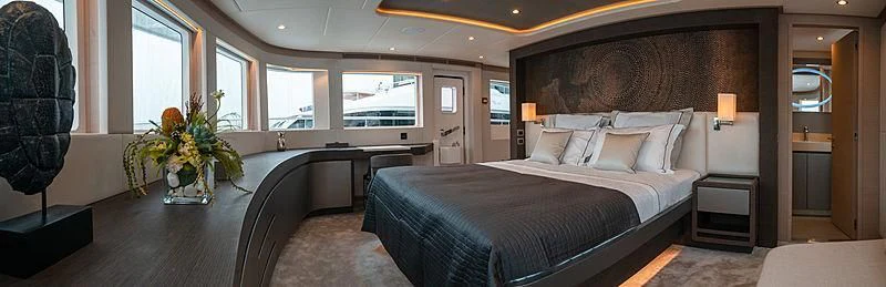 a bedroom with a bed and a desk aboard DIGNITY Yacht for Sale