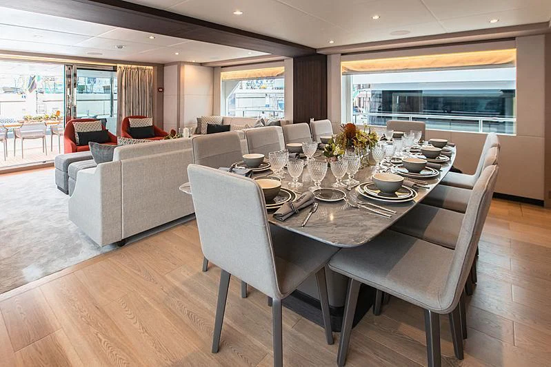 a large dining table with chairs around it aboard DIGNITY Yacht for Sale