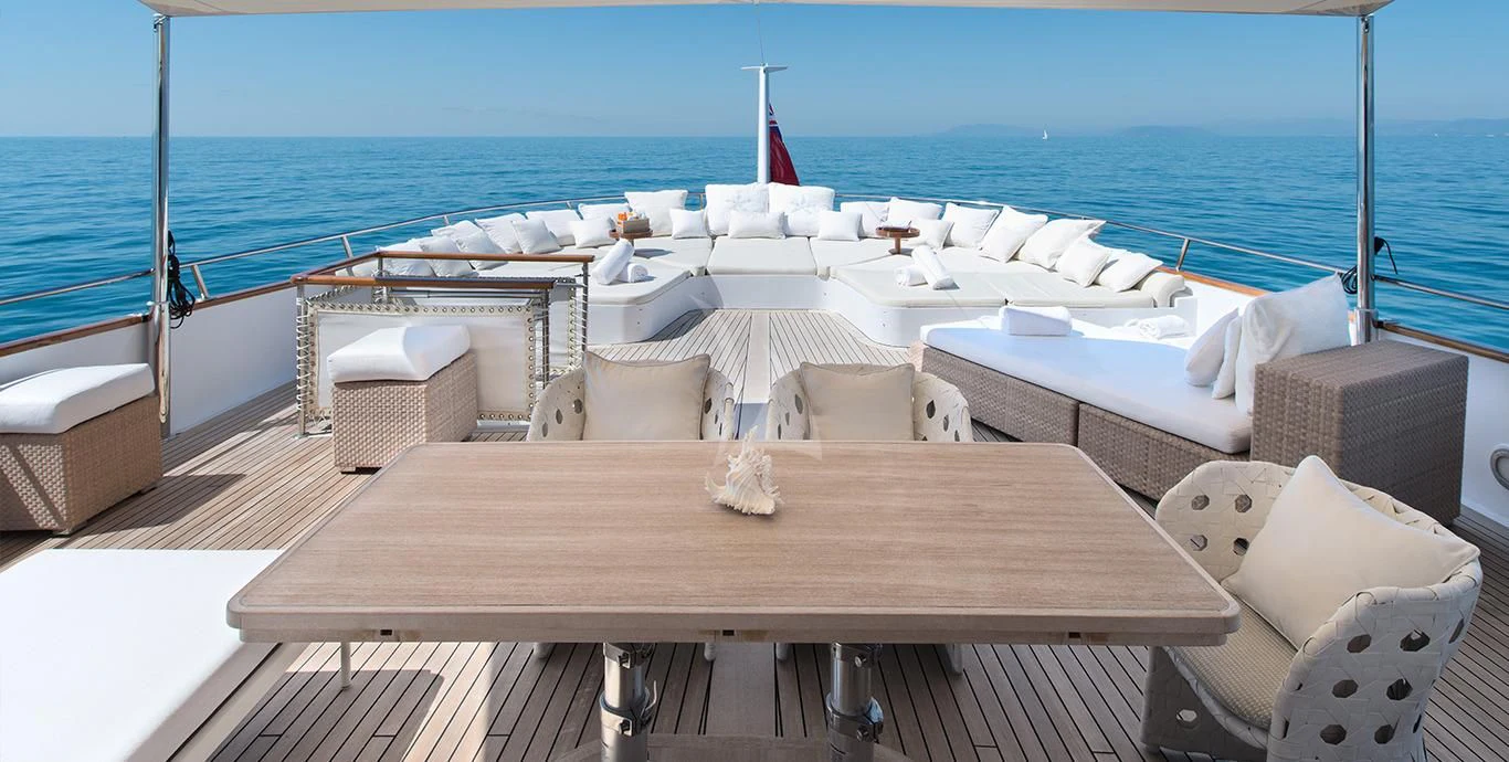 a deck with a table and chairs on it aboard SIRAHMY Yacht for Sale