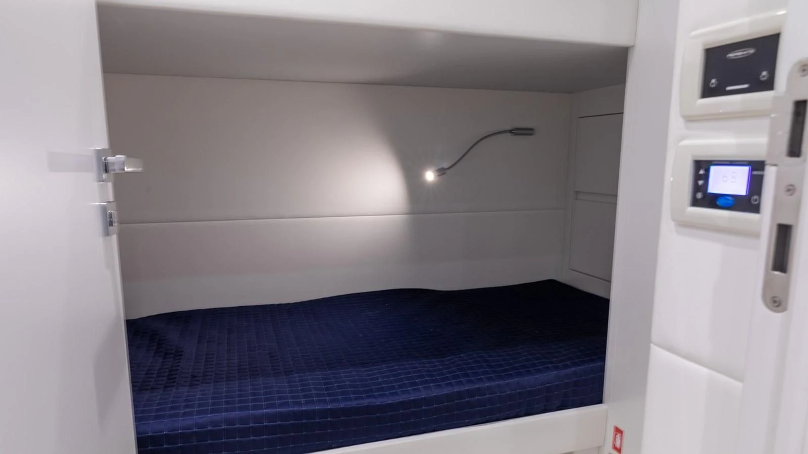 a small room with a bed and a television aboard NAAV Yacht for Sale