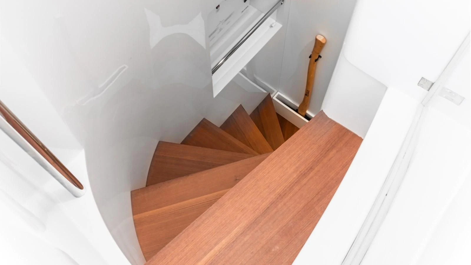 a wooden staircase with a white wall aboard NAAV Yacht for Sale