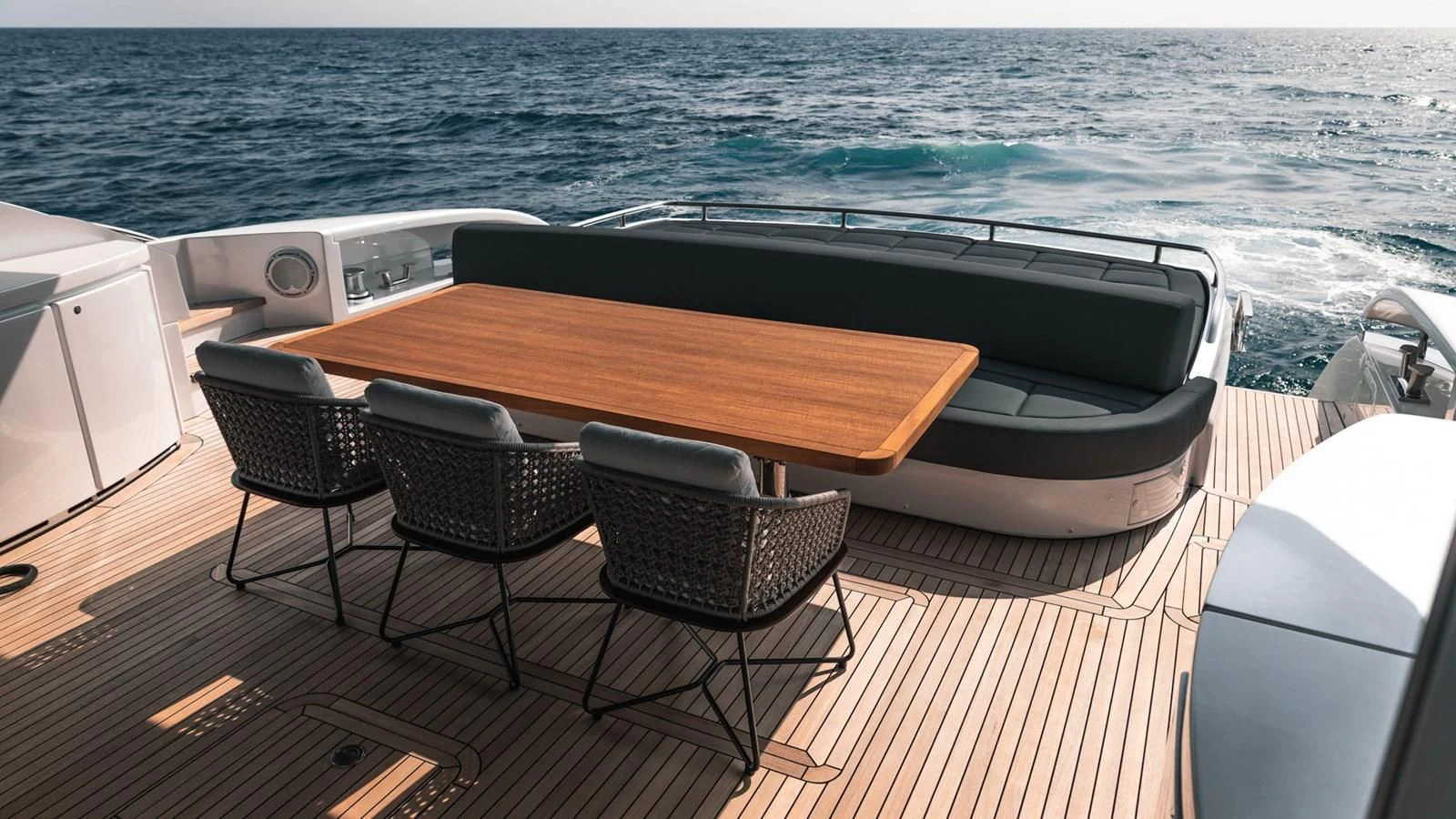 a table and chairs on a deck overlooking the ocean aboard NAAV Yacht for Sale