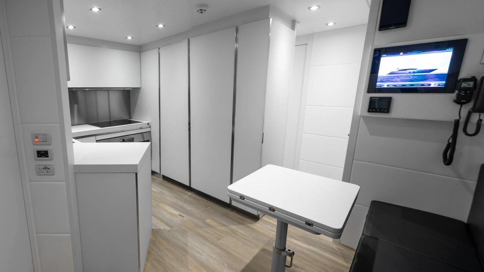 a room with a table and a tv aboard NAAV Yacht for Sale