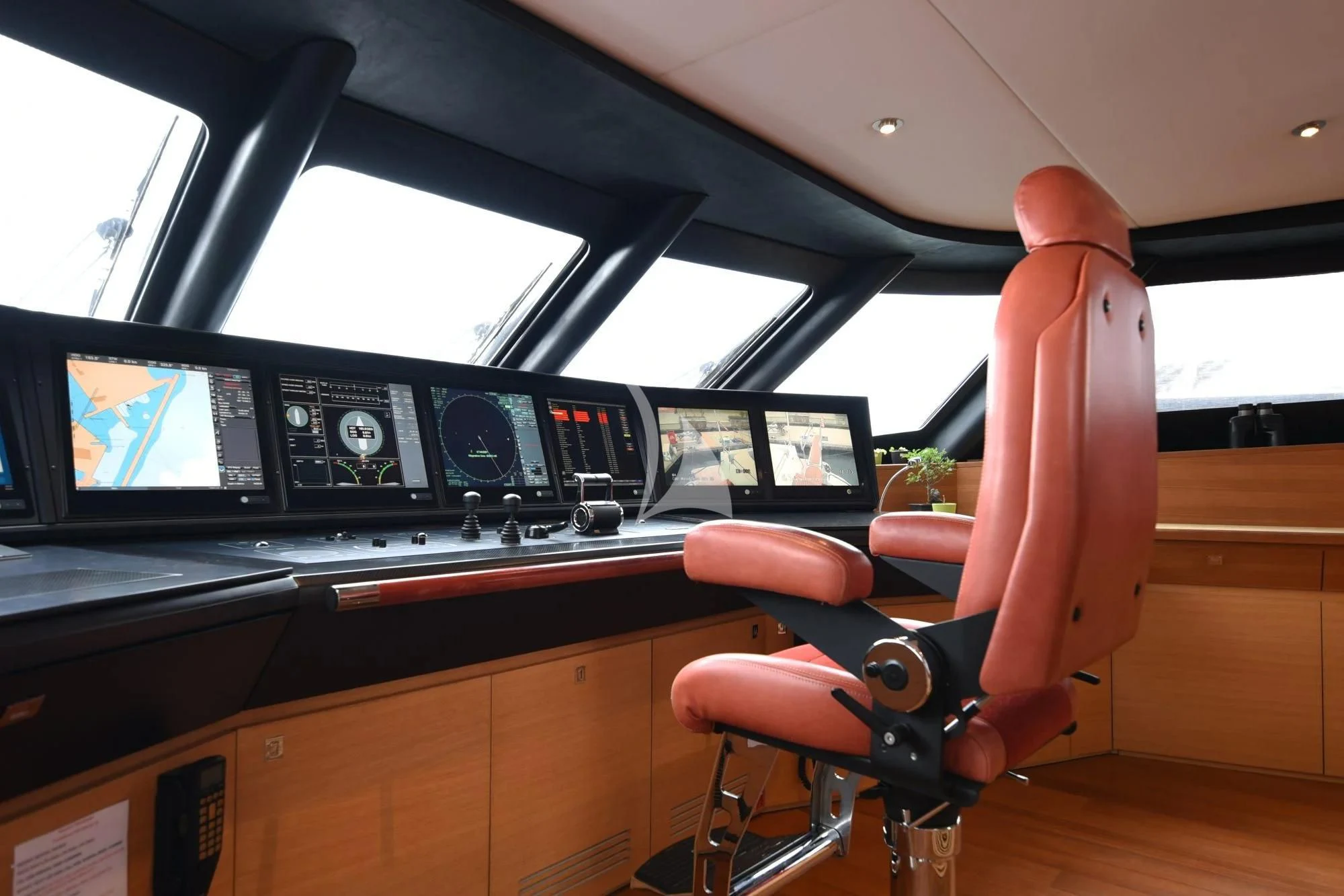 a red and orange chair in a room with a large tv and a wood floor and a wood aboard LIFE SAGA Yacht for Sale