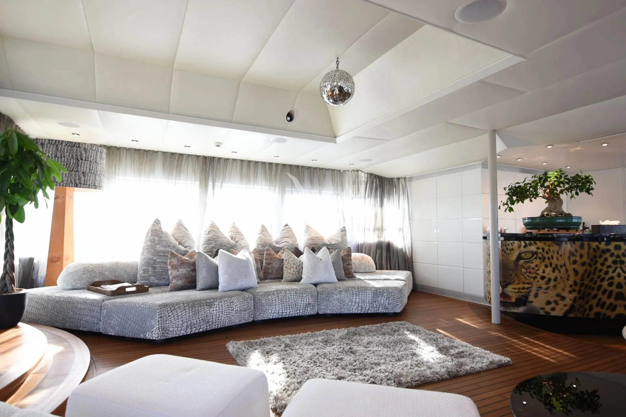 a living room with a large white couch and a large window aboard LIFE SAGA Yacht for Sale