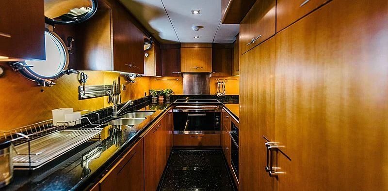 a kitchen with wooden cabinets aboard CARPE DIEM Yacht for Sale