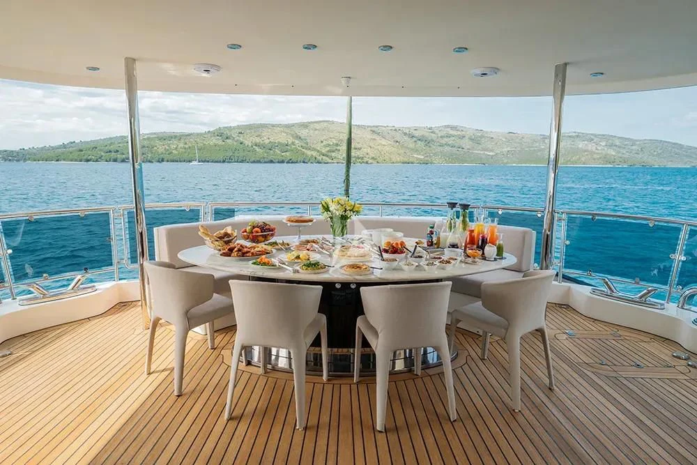 a table set for a meal on a deck overlooking a body of water aboard CARPE DIEM Yacht for Sale