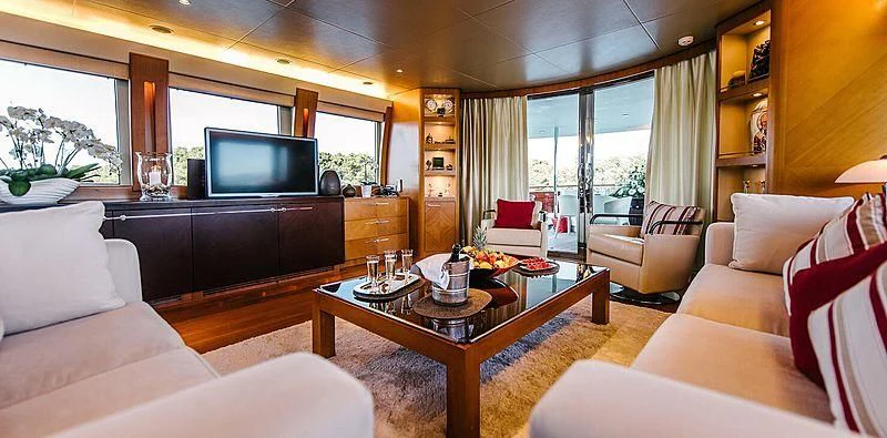 a living room with a tv and a table aboard CARPE DIEM Yacht for Sale