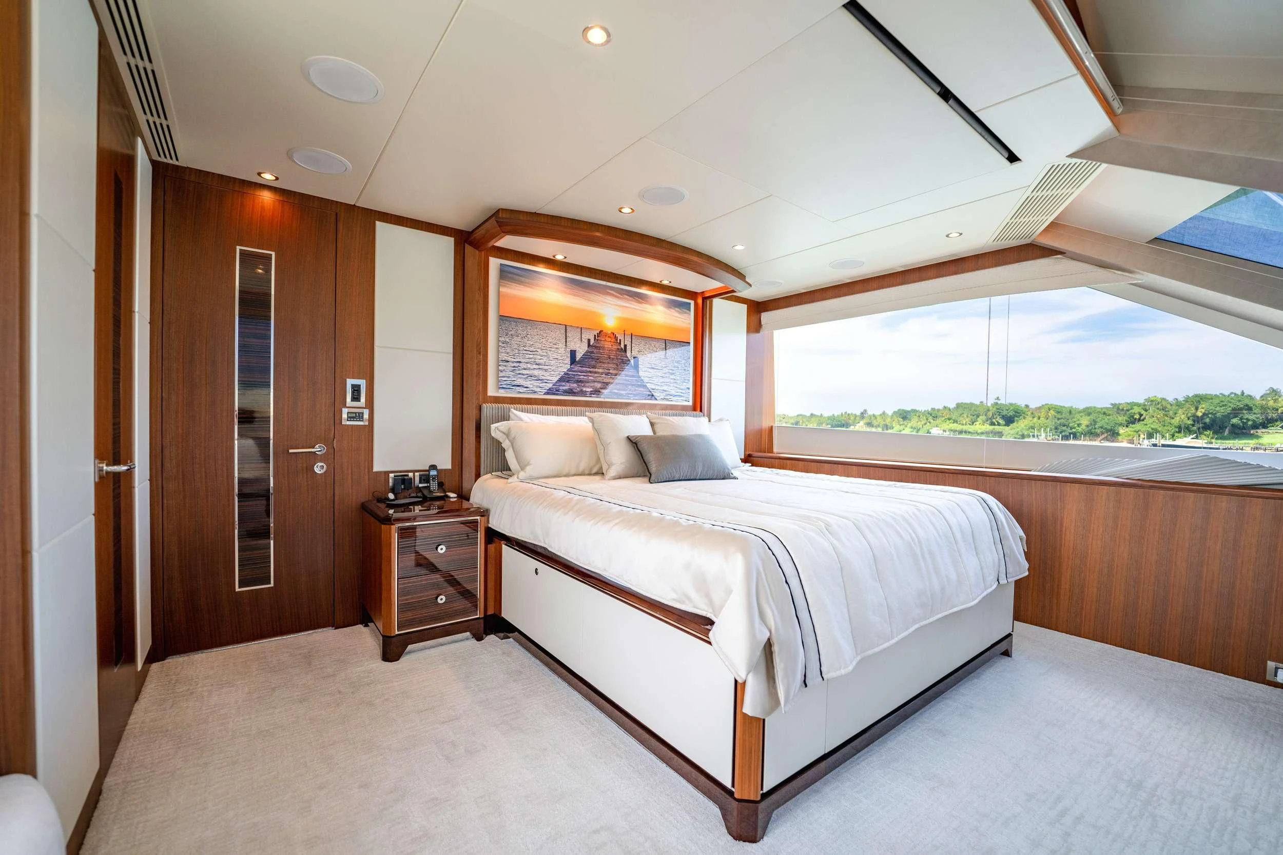 a bedroom with a bed and a wood cabinet aboard ZEPHYR Yacht for Charter