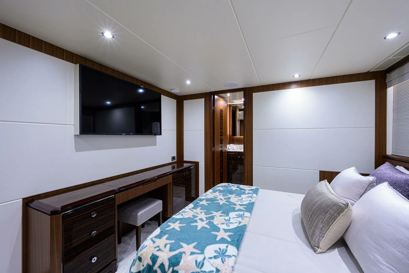a bedroom with a bed and desk aboard ZEPHYR Yacht for Charter
