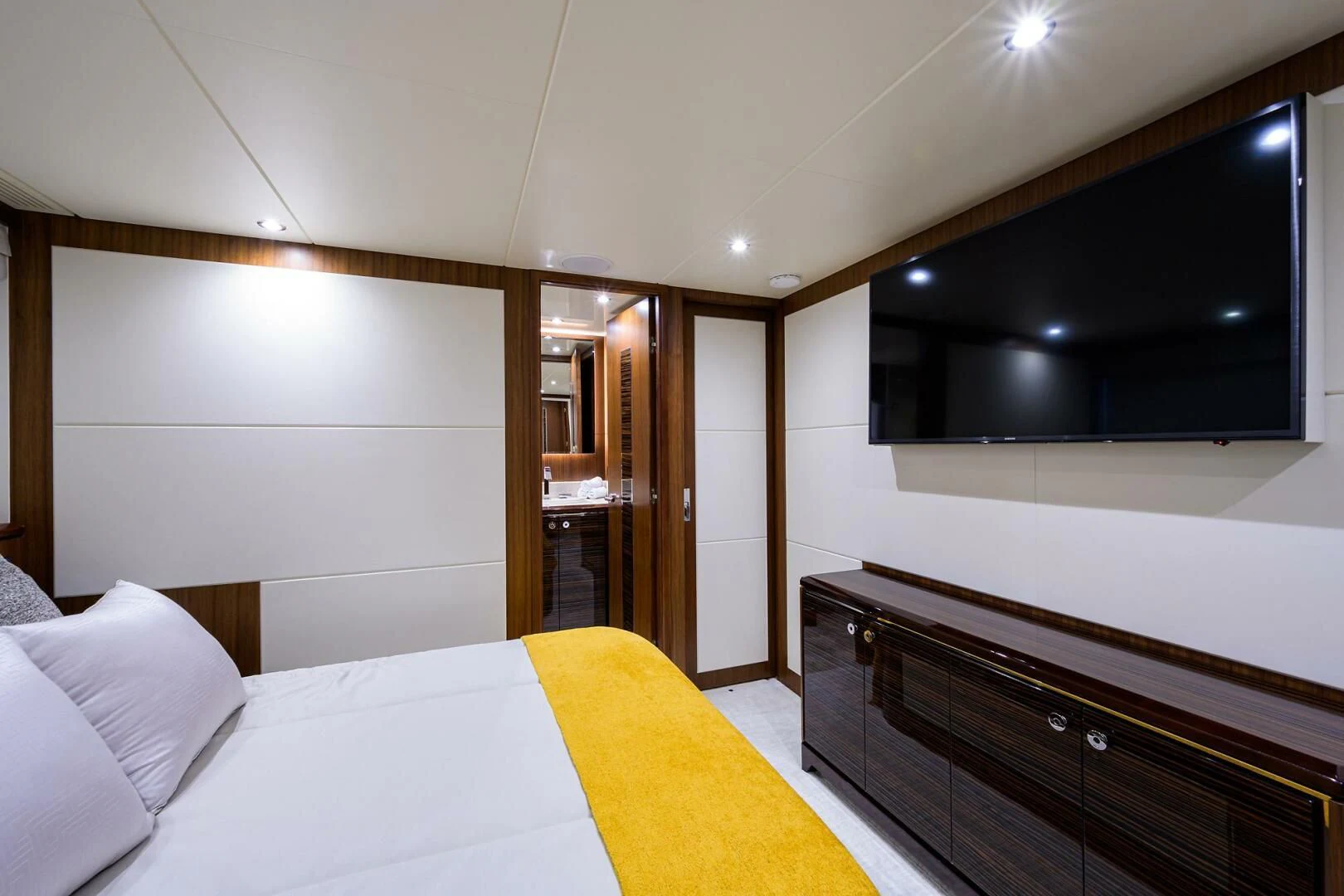 a bedroom with a bed and a tv on the wall aboard ZEPHYR Yacht for Charter