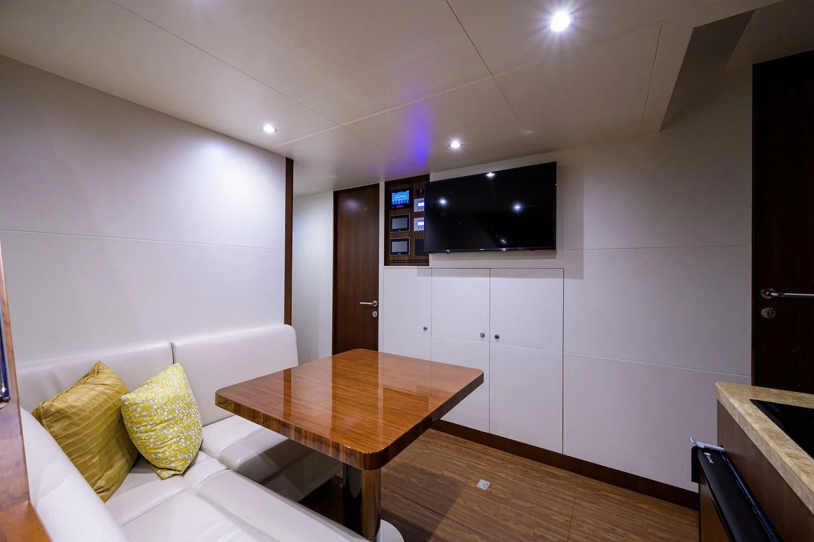 a room with a table and a tv on the wall aboard ZEPHYR Yacht for Charter