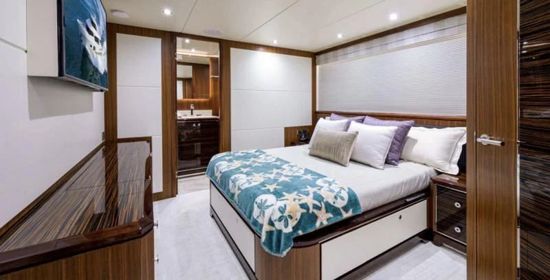 a bedroom with a bed and a dresser aboard ZEPHYR Yacht for Charter