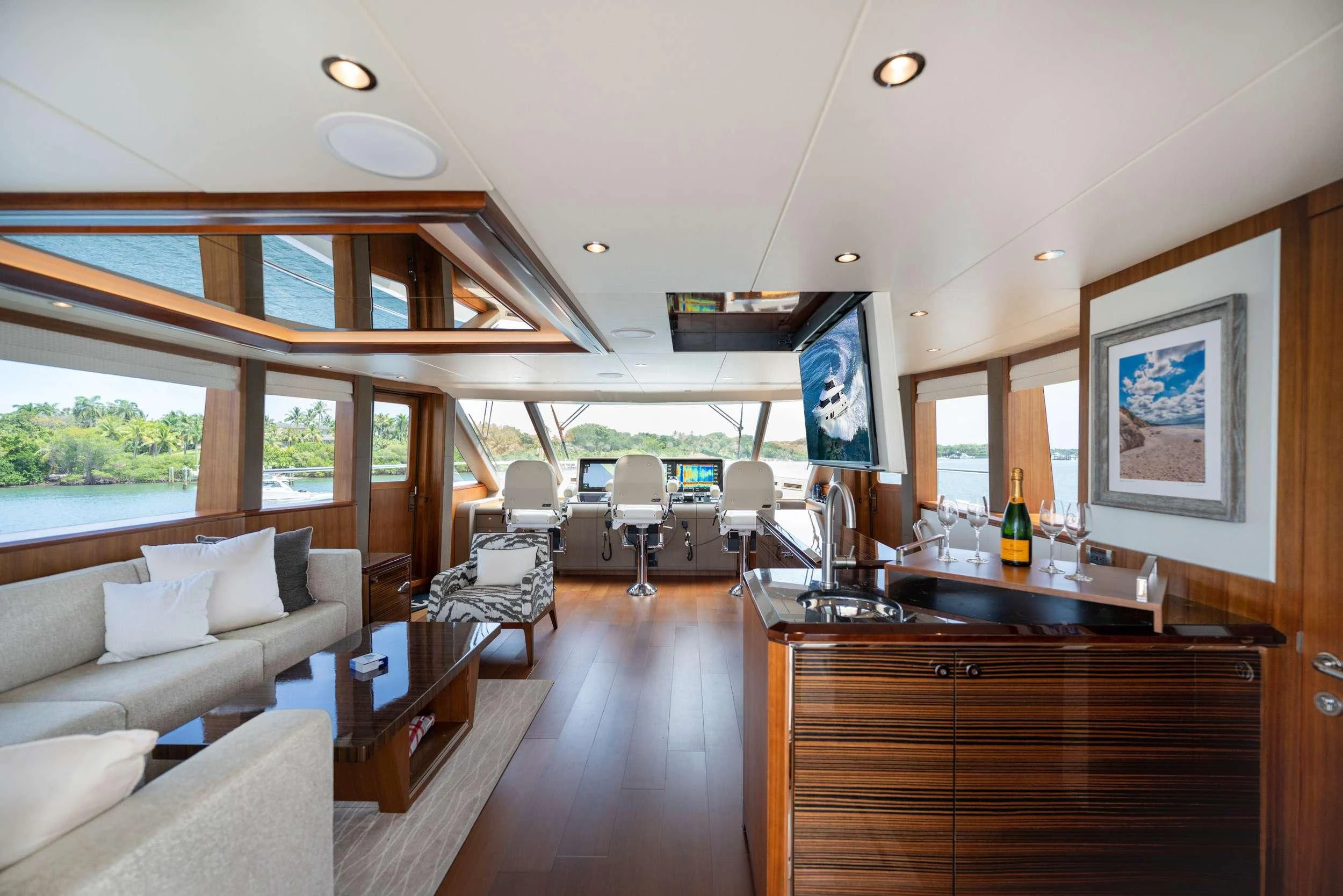 a room with a large window and a wood table with chairs and a large window with a view aboard ZEPHYR Yacht for Charter