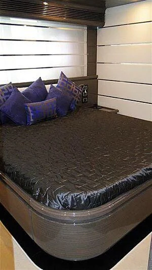 a bed with blue pillows aboard PRATA DO LYS Yacht for Sale