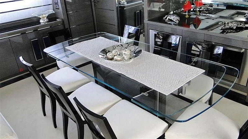 a table with chairs and a plate of food on it aboard PRATA DO LYS Yacht for Sale