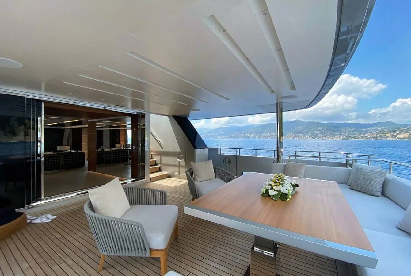 a large room with a table and chairs and a large body of water aboard LADY A Yacht for Sale