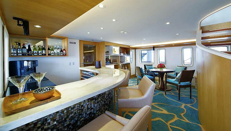 a kitchen with a bar and a table aboard SALILA Yacht for Sale