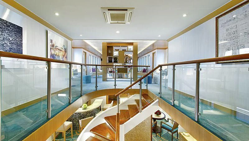 a large room with a staircase and glass walls aboard SALILA Yacht for Sale
