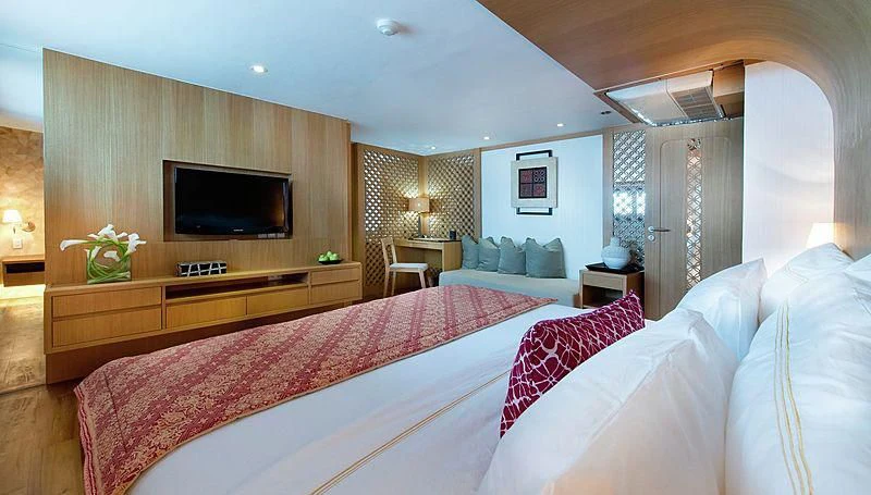 a bedroom with a large bed and a tv aboard SALILA Yacht for Sale