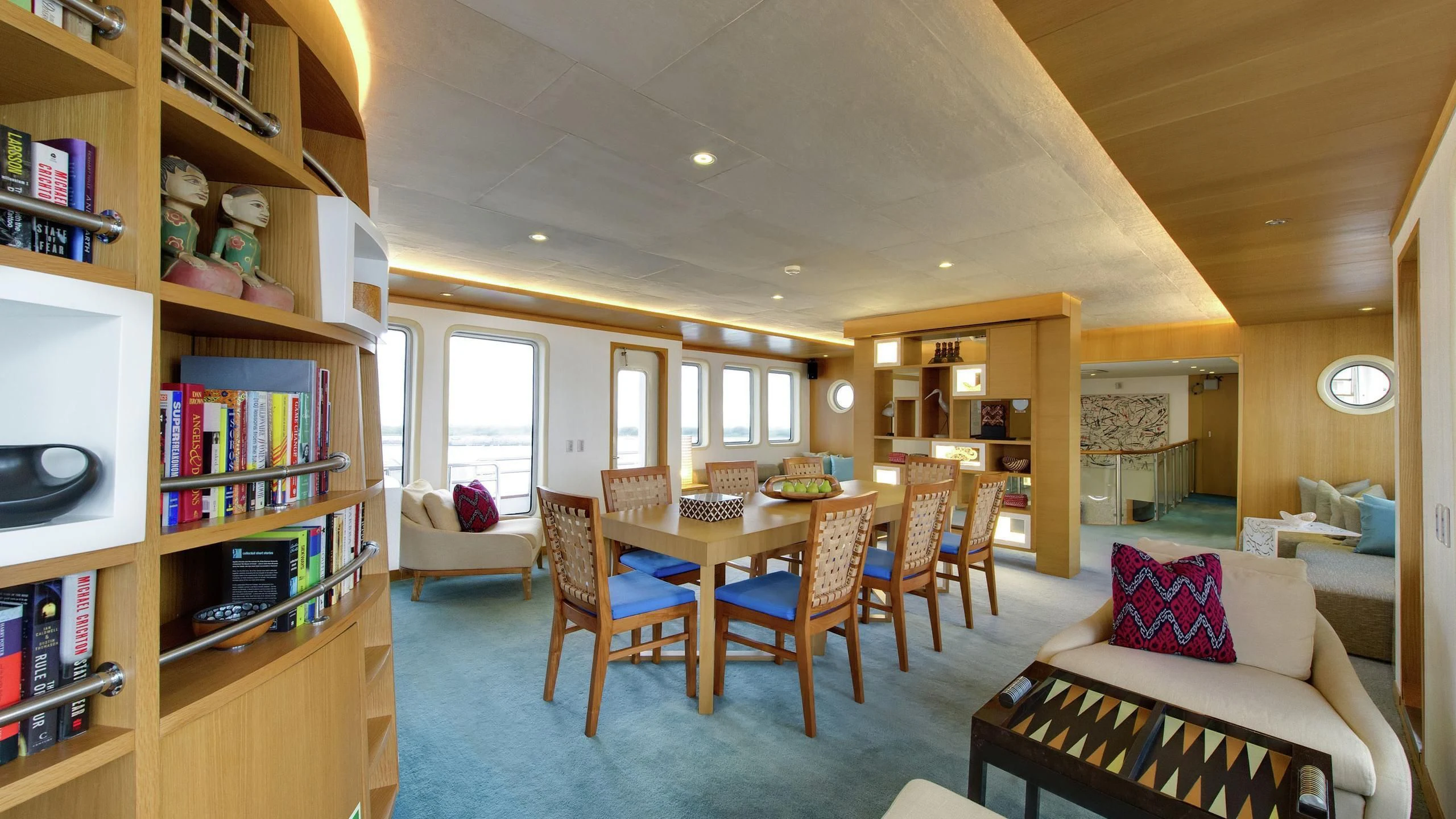 a living room with a bookcase and chairs aboard SALILA Yacht for Sale