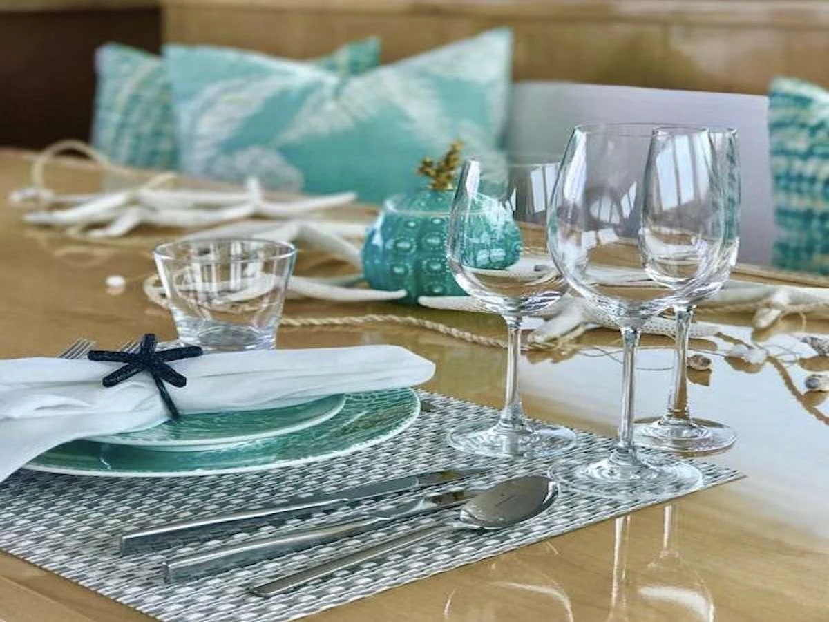 a table with wine glasses and plates aboard LAYSAN Yacht for Sale