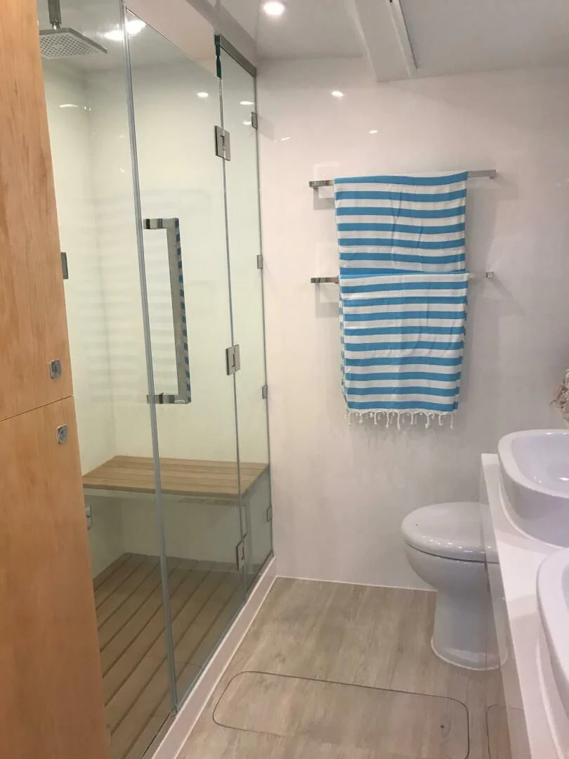 a bathroom with a glass shower aboard LAYSAN Yacht for Sale