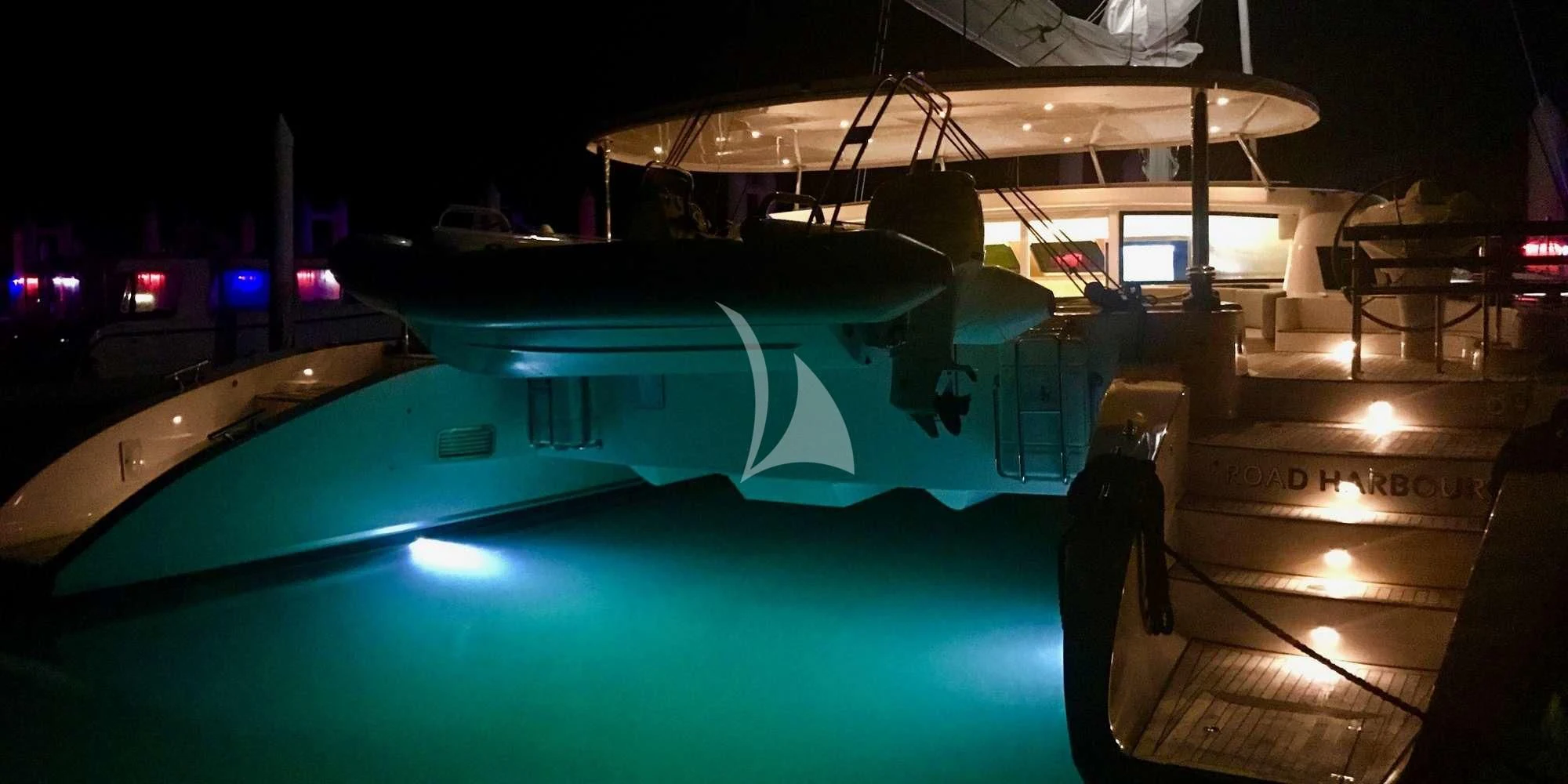 a pool with a blue lit up pool and a large building in the background aboard LAYSAN Yacht for Sale