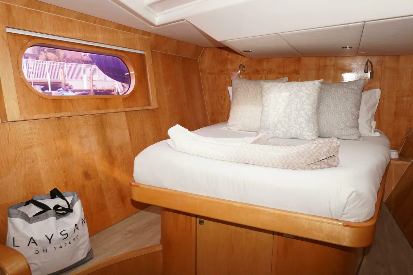 a bed with a white pillow and a white bag on it aboard LAYSAN Yacht for Sale