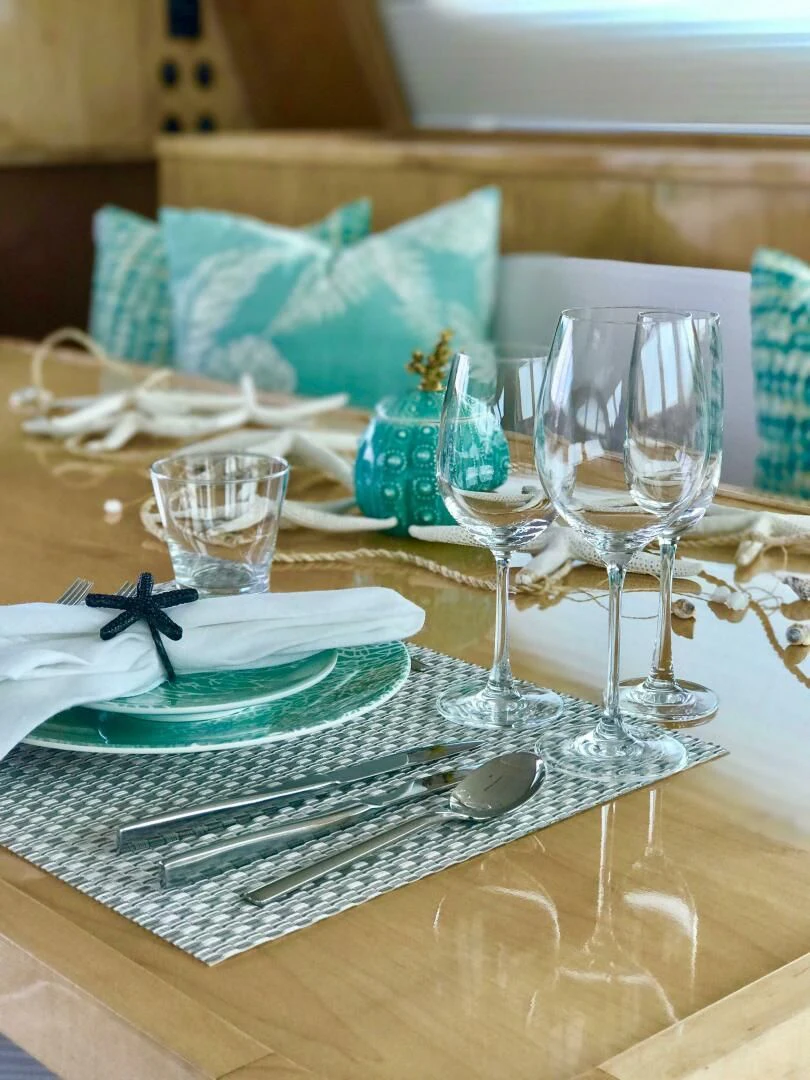 a table with plates and glasses aboard LAYSAN Yacht for Sale