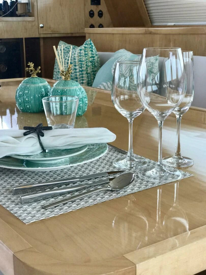 a table with plates and glasses aboard LAYSAN Yacht for Sale