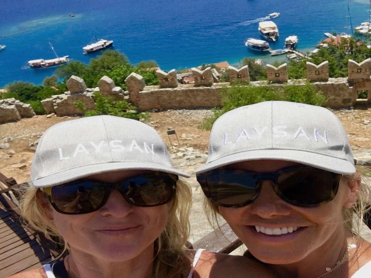 a couple of women wearing sunglasses and hats taking a selfie aboard LAYSAN Yacht for Sale
