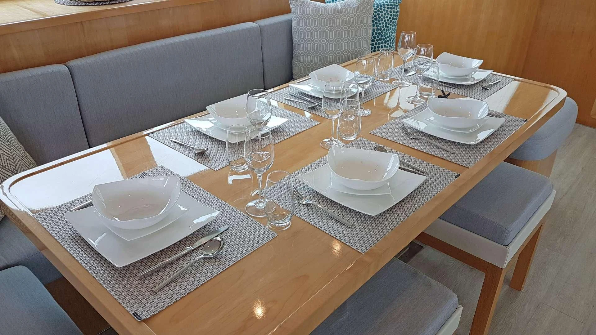 a table with plates and glasses on it aboard LAYSAN Yacht for Sale