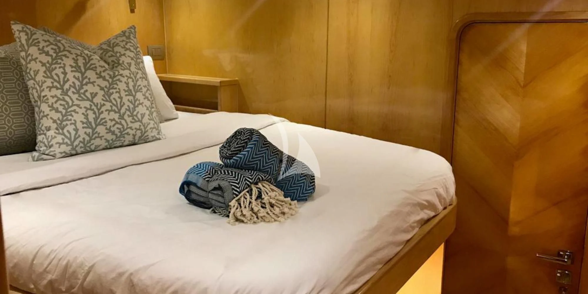 a bed with a white sheet and pillows on it aboard LAYSAN Yacht for Sale