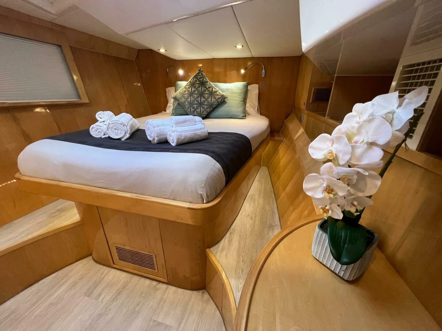 a bed with white flowers in a room with a window aboard LAYSAN Yacht for Sale
