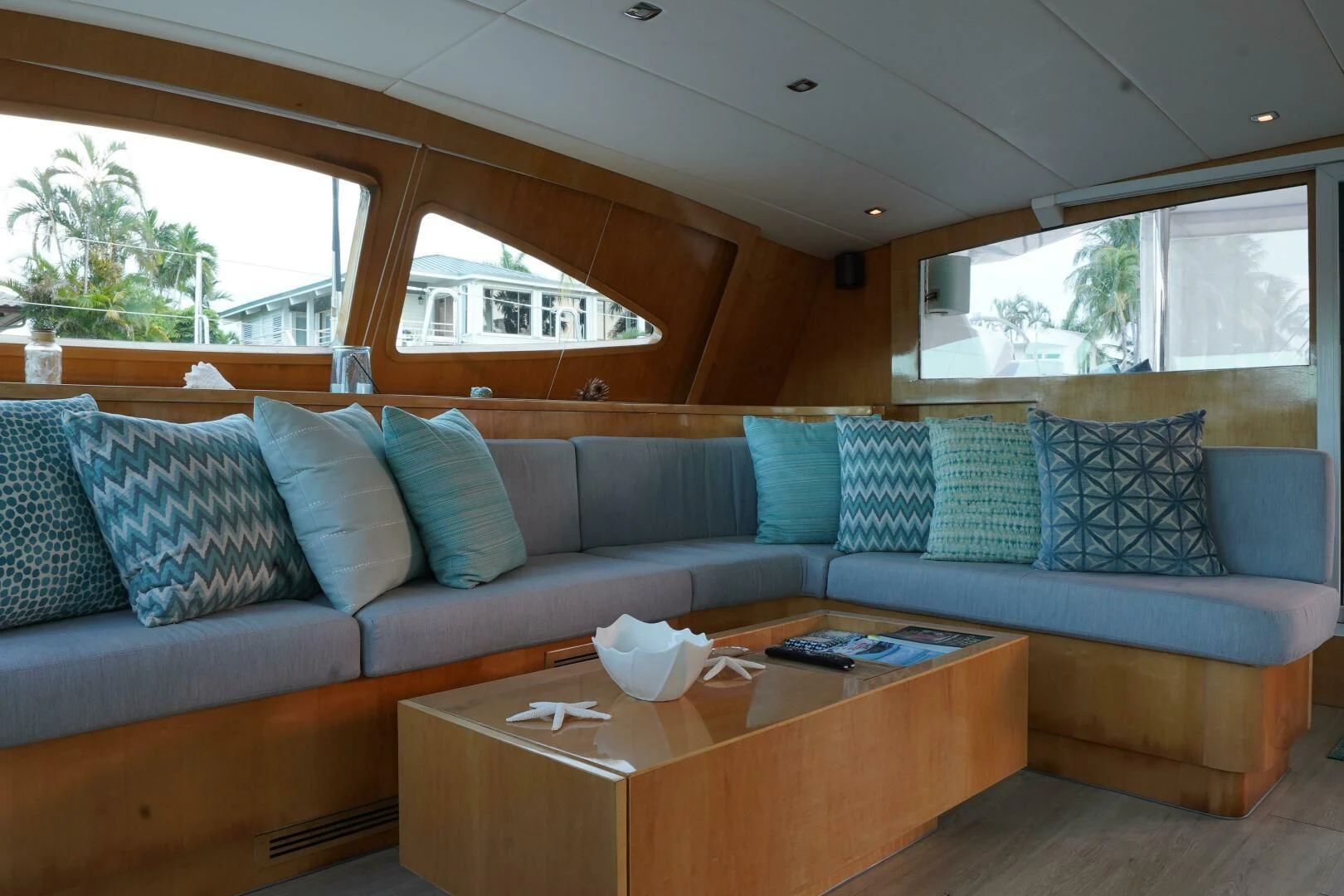 a couch with pillows and a coffee table in a room with a window aboard LAYSAN Yacht for Sale