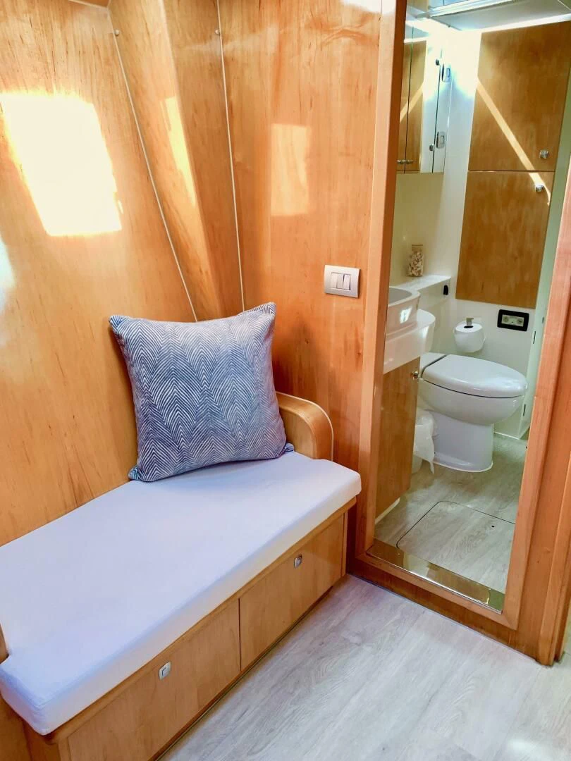 a small bathroom with a wood door aboard LAYSAN Yacht for Sale