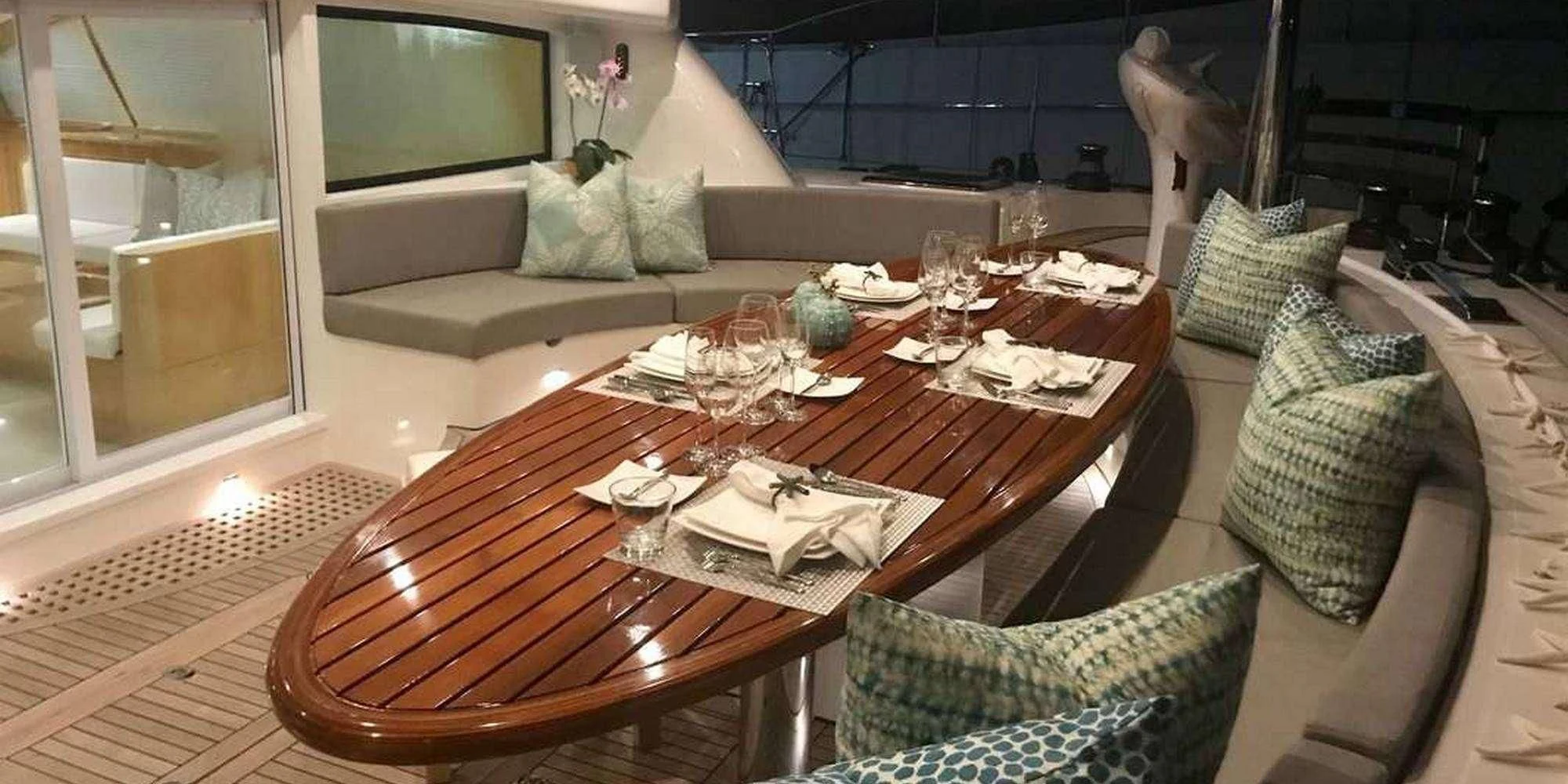 a table with a set of chairs and a couch with a television in the background aboard LAYSAN Yacht for Sale