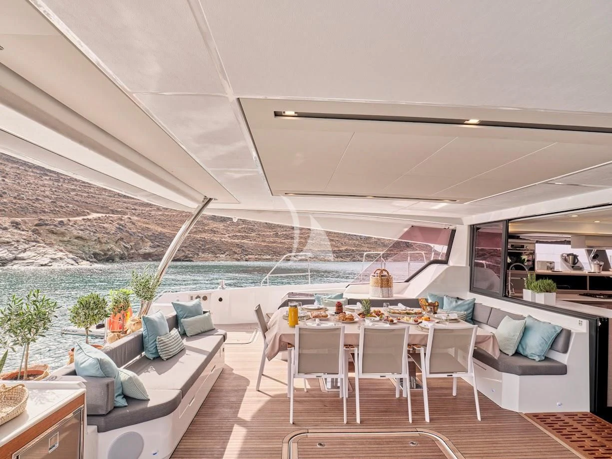 a room with a table chairs and a large body of water aboard DOLLY Yacht for Charter