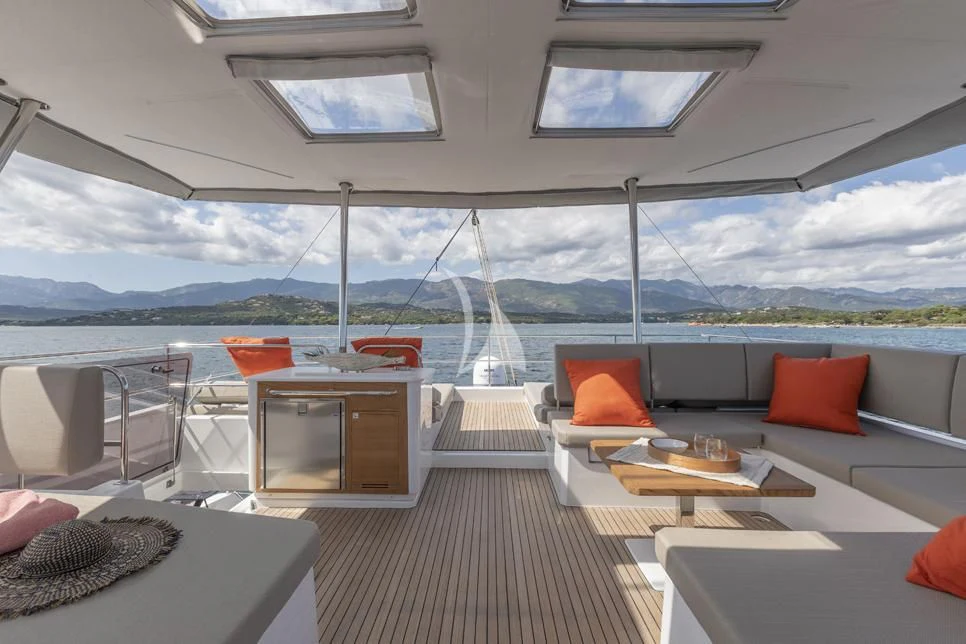 a room with a couch and a table and a large window aboard DOLLY Yacht for Charter
