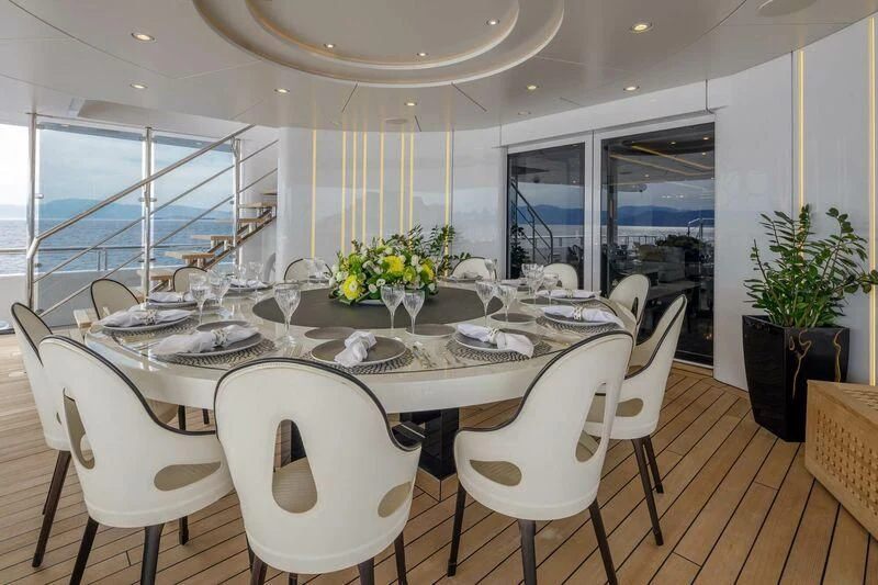 a dining table with white chairs aboard LADY VERA Yacht for Sale