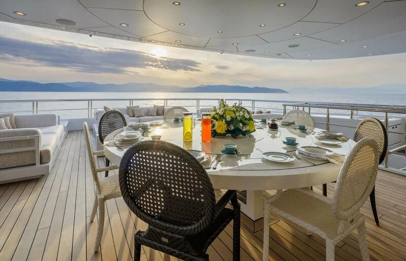 a table set for a meal on a deck overlooking the ocean aboard LADY VERA Yacht for Sale