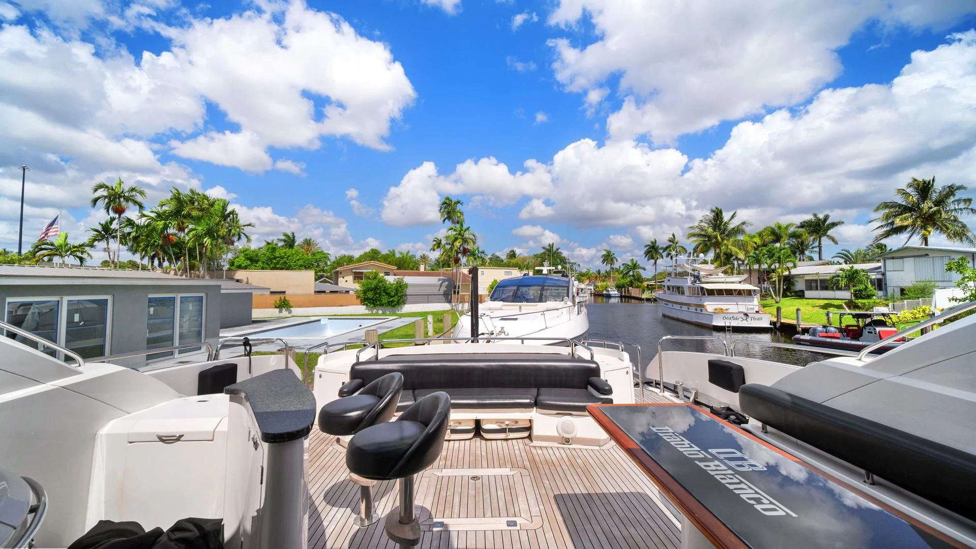 a deck with a chair on it and boats in the water aboard DIABLO BLANCO Yacht for Sale