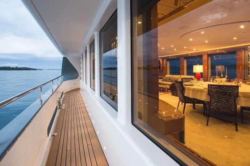 a balcony with a table and chairs on the deck aboard LADY MM Yacht for Sale