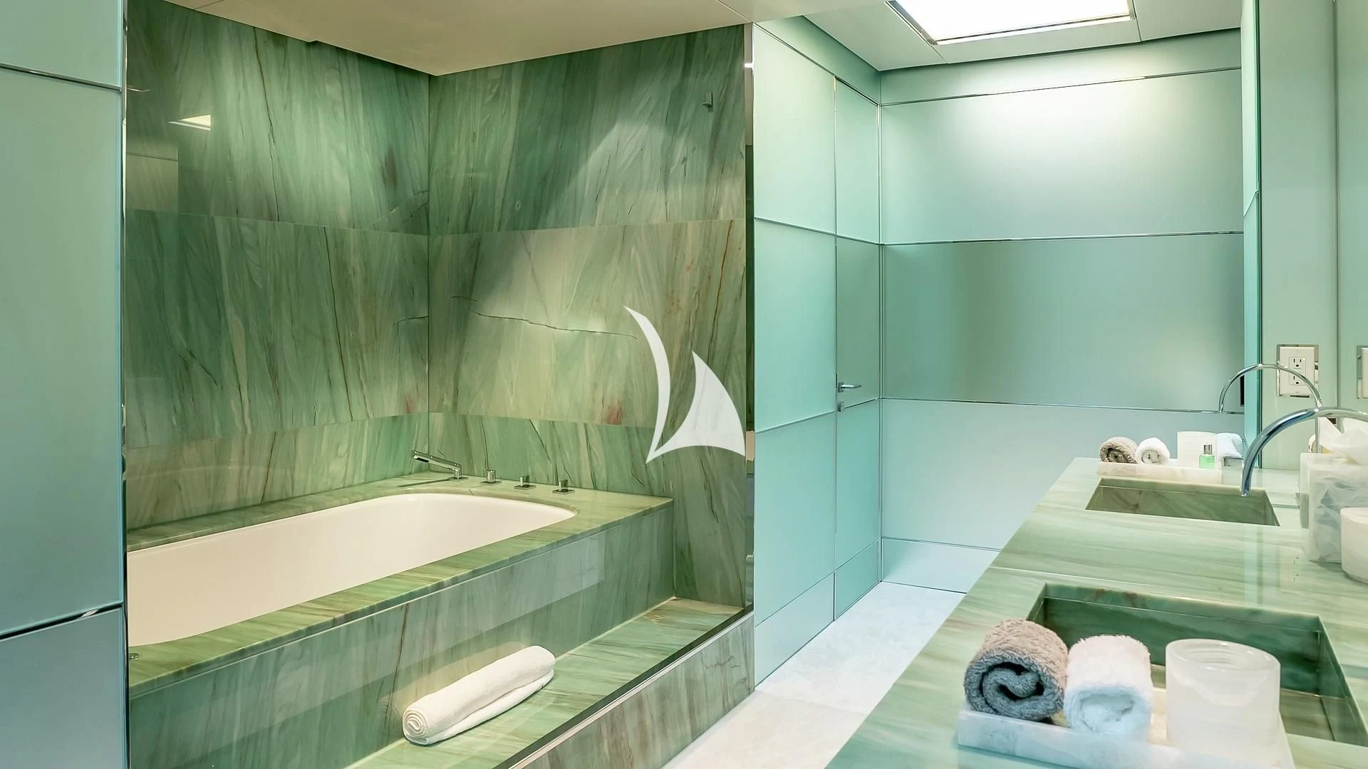 a bathroom with a bathtub and sinks aboard ODESSA Yacht for Sale