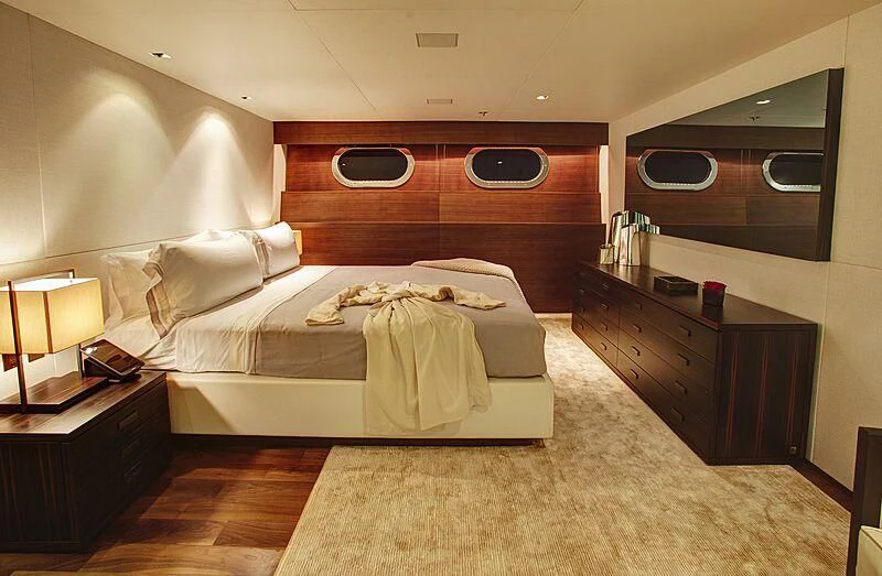 a bedroom with a bed and a dresser aboard ODESSA Yacht for Sale
