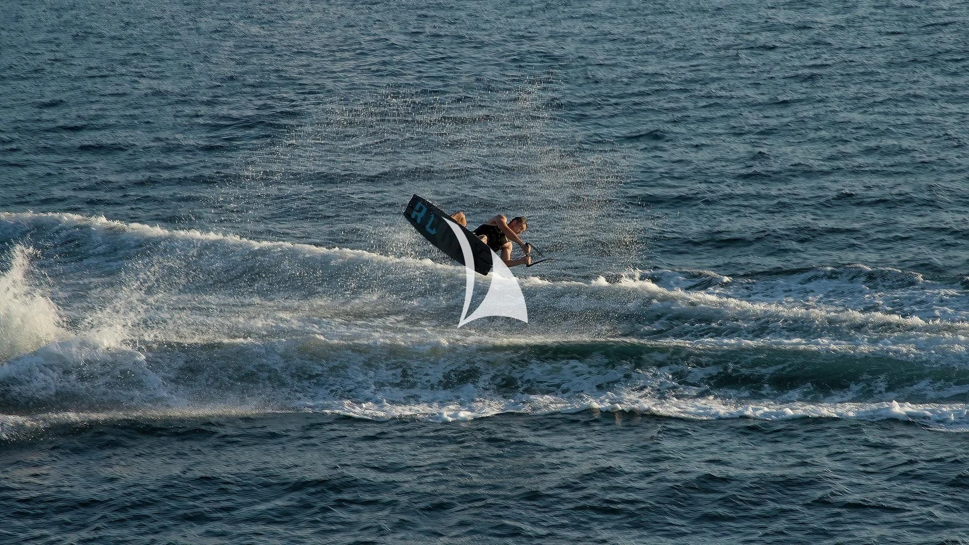 a man surfing on the waves aboard ODESSA Yacht for Sale